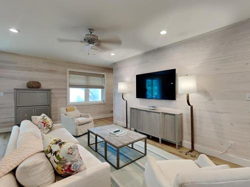 een woonkamer met witte meubels en een flatscreen-tv bij Cottages at Old Bay #5 in Orange Beach