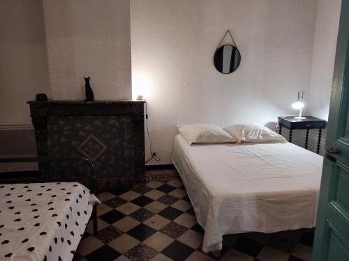 a bedroom with two beds and a cat sitting on the wall at Libellule in Argelès-sur-Mer