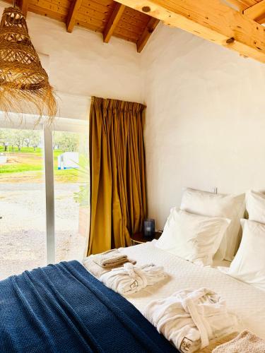 a bedroom with a bed with towels on it at Valle D`Água - Casas de campo in Vale de Água