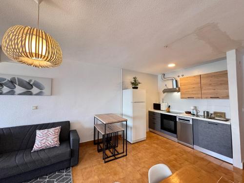 un salon avec un canapé et une cuisine dans l'établissement PUSHE Playa Velilla Beach&Tradition, à Almuñécar