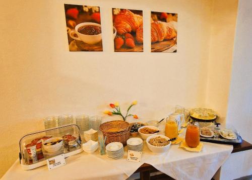 a table with food on it with pictures on the wall at Hotel Garni Schlossblick in Hohenschwangau