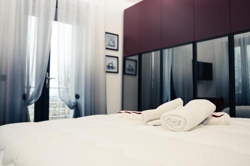 a white bed with two towels on top of it at House 21 Residence Room in Collecchio