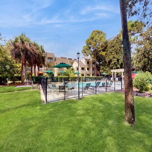 a fence in a yard with a swimming pool at Walk to the Beach and Coligny! in Hilton Head Island