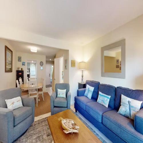 a living room with a blue couch and chairs at Walk to the Beach and Coligny! in Hilton Head Island