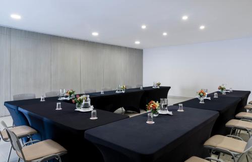 a row of tables in a room with chairs at Hotel MS Ciudad Jardin in Cali