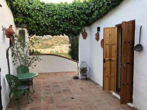 a patio with a table and chairs in a building at Casita with Views of Frigiliana in Frigiliana