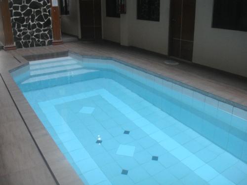 a swimming pool with blue tiles on the floor at Hidden Pearl Hotel (Janus Luxury Suites) in Angeles