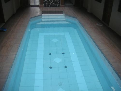 a swimming pool with blue tiles on the floor at Hidden Pearl Hotel (Janus Luxury Suites) in Angeles