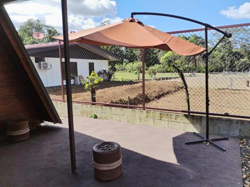 an umbrella sitting on a patio next to a fence at Sol y Luna Chalet in Fortuna