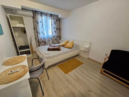 una pequeña habitación con una cama y una mesa en Данделион, en Burgas