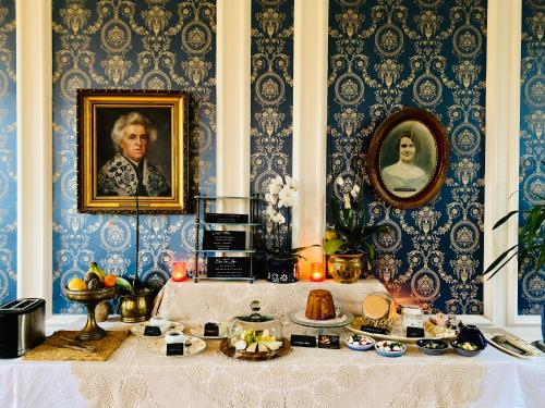 une chambre avec une table et un portrait d'un homme dans l'établissement Chambre d'hôtes Sarah - Château Le Bas Bleu, à Quesnoy-le-Montant