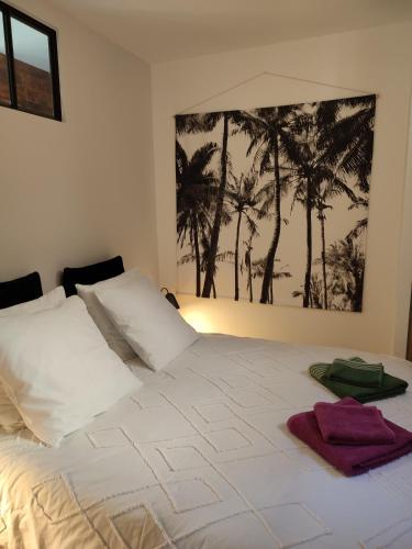 un lit blanc avec deux serviettes dessus dans l'établissement appartement cosy tout confort, à Troyes