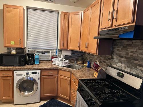 a kitchen with wooden cabinets and a washing machine at Entire Apt in Heart of Chicago in Chicago