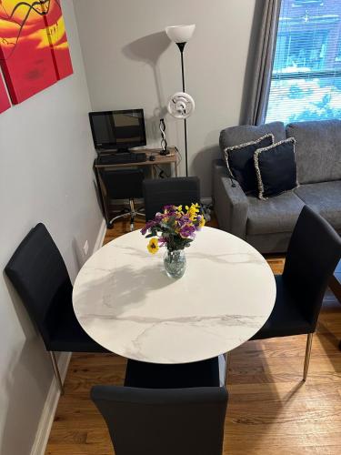 a table with a vase of flowers on it in a living room at Entire Apt in Heart of Chicago in Chicago