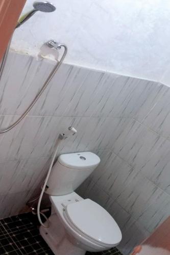 a bathroom with a toilet and a shower at Homestay Wong Kito in Andalas
