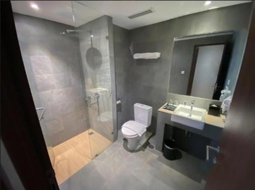 a bathroom with a toilet and a sink and a shower at Nemuru Grand Bhuvana Ciawi in Bogor