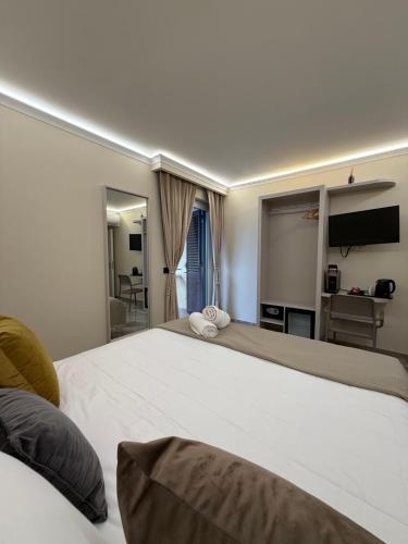 a bedroom with a large white bed and a television at Bonocore Accomodation in Tropea