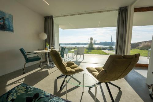 a living room with chairs and a large window at Luxe apartment direct aan de rivier in Rhenen