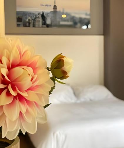 a flower in a vase next to a bed at Domus Suites Chia in Chía
