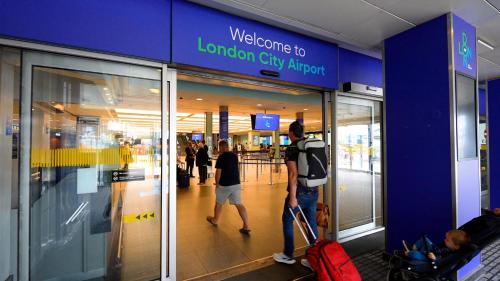 a man and a woman walking through a london city airport at London Dockside 3 Bed in London