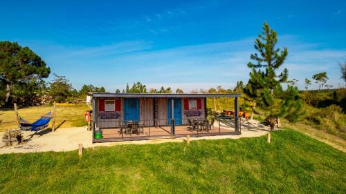a tiny house with a porch and a swing at Casa de Campo in Los Santos