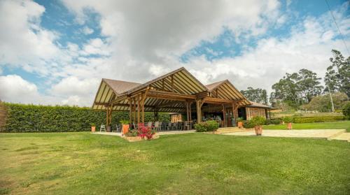 a pavilion with a roof on a grass field at Casa de Campo in Los Santos