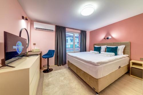 a bedroom with a bed and a desk with a television at Апартамент за гости Райково in Smolyan
