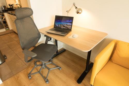 a laptop computer sitting on a desk with a chair at My Dublin Nest in Dublin