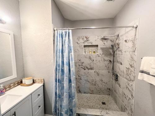 a bathroom with a shower with a blue shower curtain at Homestead Green retreat in Homestead