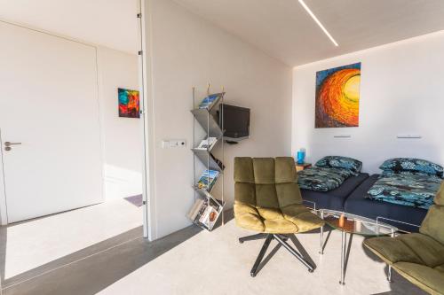 a living room with a couch and a chair at Luxe apartment direct aan de rivier in Rhenen