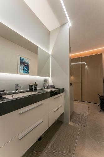 a kitchen with white cabinets and a sink at Luxe apartment direct aan de rivier in Rhenen