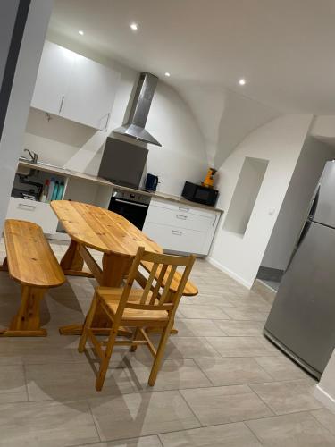 une cuisine avec une table et des chaises en bois dans l'établissement Maison de village, à Saint-Jean-de-Fos