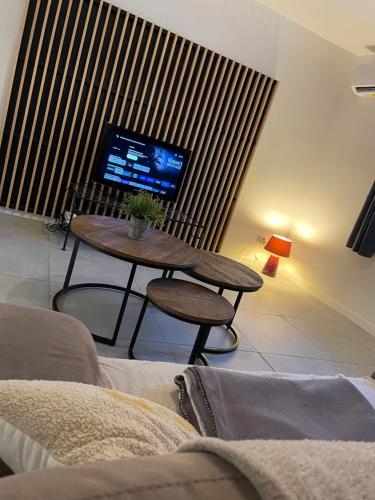 un salon avec une table et une télévision dans l'établissement Maison de village, à Saint-Jean-de-Fos