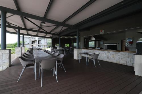 a restaurant with a table and chairs on a deck at Sandpiper Villas Chobe in Kasane