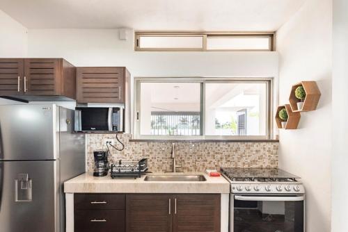 a kitchen with a stainless steel refrigerator and a sink at Casa Palancar with beautiful swimming pool and private palapa in Cozumel