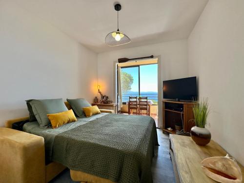 une chambre avec un lit, une télévision et une table dans l'établissement Studio vue mer, à Ajaccio
