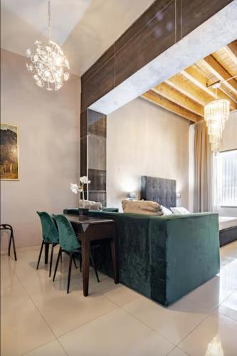 a dining room with a table and green chairs at Adhoc Boutique Barrio Antiguo in Monterrey