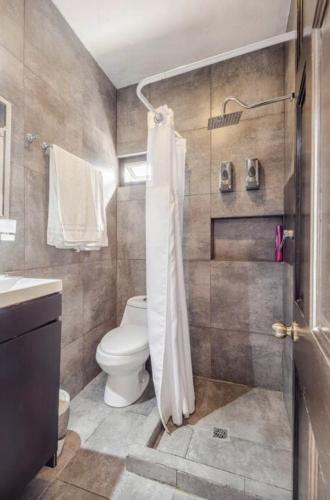 a bathroom with a toilet and a sink and a shower at Adhoc Boutique Barrio Antiguo in Monterrey