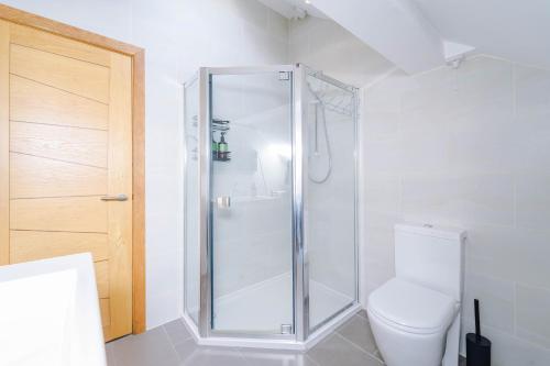 a bathroom with a shower and a toilet at Cobstone Cottage in Walmersley