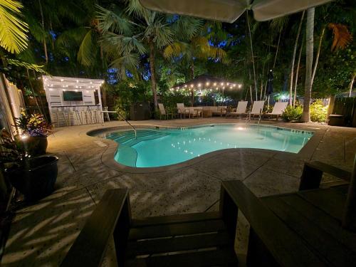 a swimming pool in a resort at night at Three Duval Street Suites w parking and pool in Key West