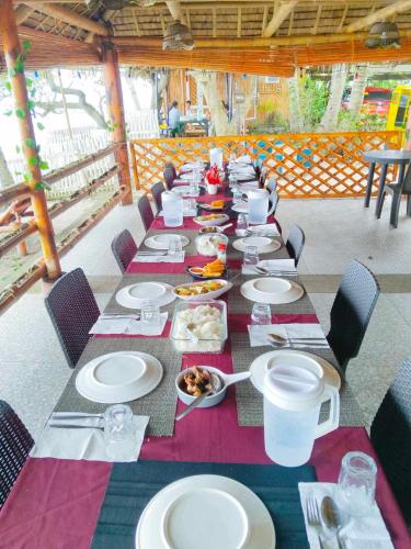 a long table with plates of food on it at Treasure Beach Resort in Carles