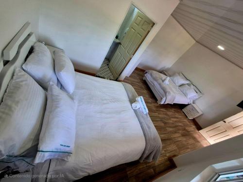 a bedroom with a large white bed with pillows at Hotel Villa Isabella Esperanza de Tinjacá Boyacá in Tinjacá