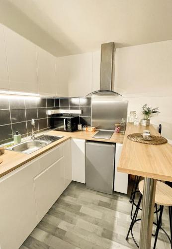 une cuisine avec des armoires blanches et un évier dans l'établissement Studio centre-ville Petite venise, à Colmar