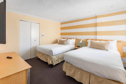 a hotel room with two beds and a desk at Pan American Oceanfront Hotel in Wildwood Crest