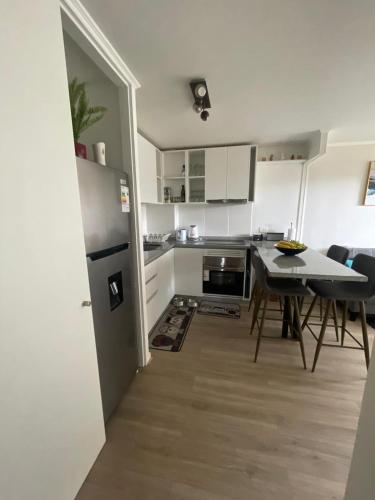 a kitchen with a table and a dining room at Departamento en Papudo, Punta Puyai in Papudo