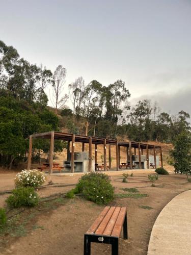 a wooden building with a bench in a park at Departamento en Papudo, Punta Puyai in Papudo