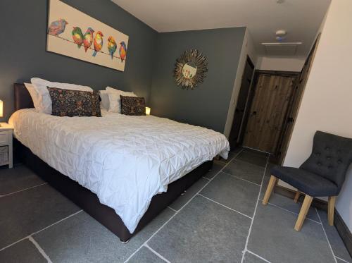 a bedroom with a bed and a chair at 5 Holiday Cottages, close to Bike Park Wales, Pen y Fan, Brecon in Merthyr Tydfil