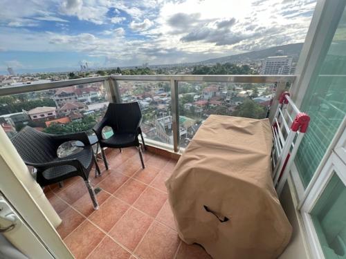 a balcony with a bed and a table and chairs at jovi's Condo one pavilion place in Cebu City