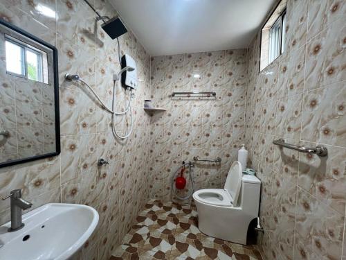 a bathroom with a toilet and a sink and a shower at Capital O 91117 Noor Room Stay in Taiping