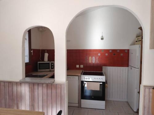 a kitchen with an archway with a stove top oven at studio haut-pays-grasse in Valderoure